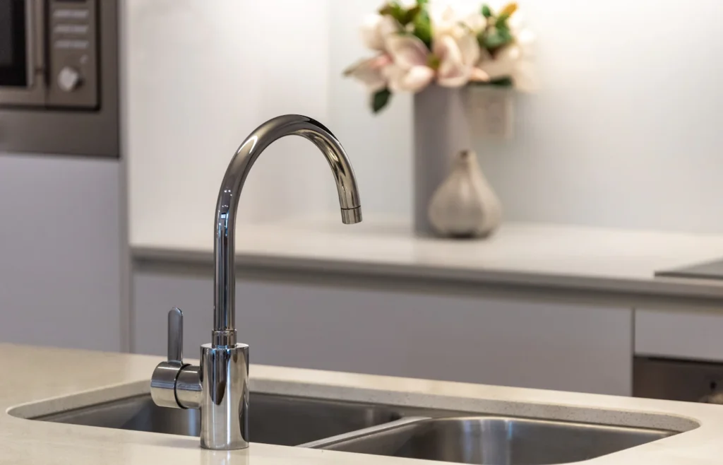 Stainless steel sink faucet above a clean drain